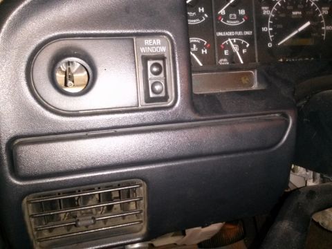 1996 Ford Bronco - Close-up of a vehicle's dashboard, showing the ignition, rear window controls, and various gauges.