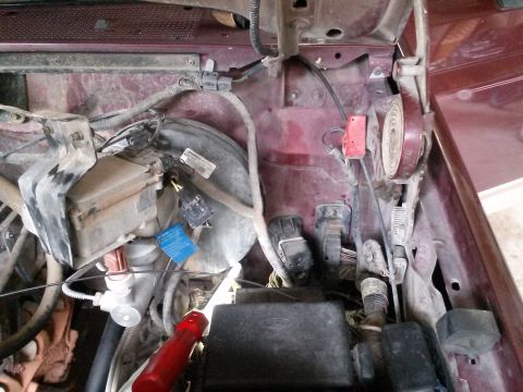 1996 Ford Bronco - Close-up view of the engine bay, showing various electrical components and the brake booster assembly.