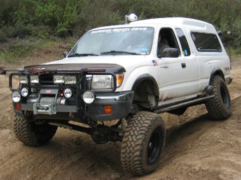 1989 Ford Bronco - This white pickup truck is equipped for off-road use with a winch and brush guard.