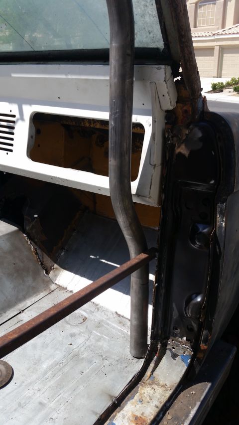 1979 Ford Bronco - The interior of a 1979 Ford Bronco shows a roll cage and significant rust on the floor panels.