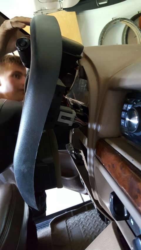 1996 Ford Bronco - A person works on the exposed wiring and dashboard components of a vehicle's interior.