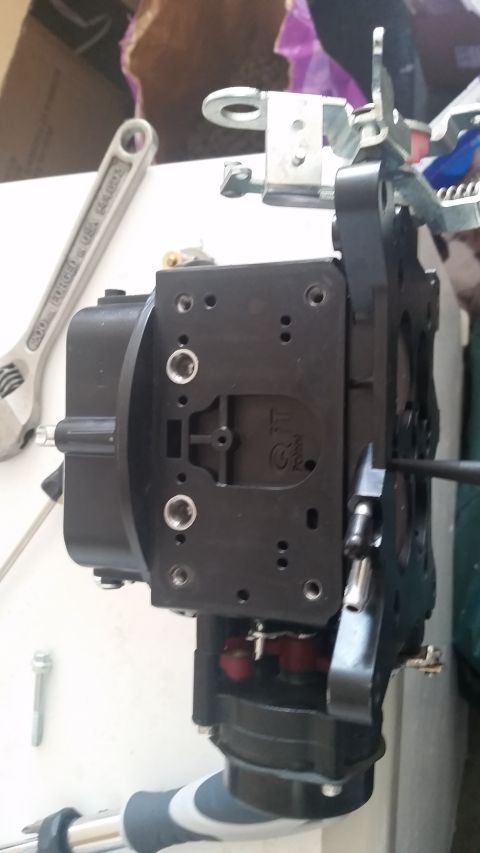 1981 Ford Bronco - A close-up view of a carburetor part, with a wrench visible in the background.