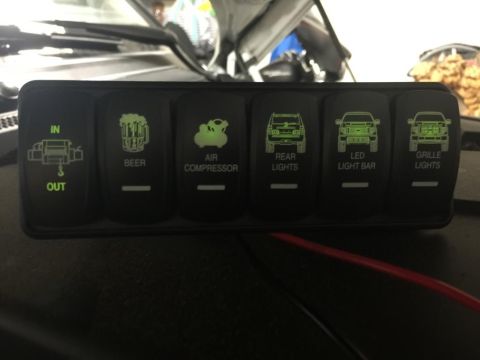 1996 Ford Bronco - This rocker switch panel features illuminated icons for various accessories, including a winch, air compressor, and lighting options.