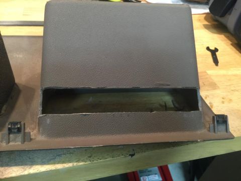 1996 Ford Bronco - A close-up view of a brown plastic dashboard trim piece with a large opening, possibly for a radio or storage.