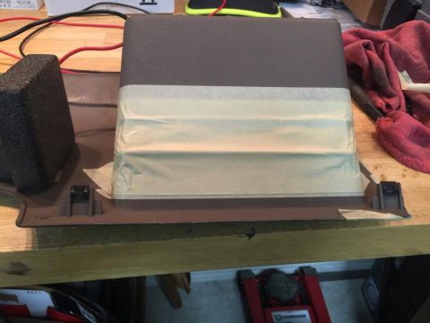 1996 Ford Bronco - A dashboard trim piece is prepared with masking tape, likely for modification or repair.