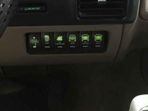 1996 Ford Bronco - Interior shot of a vehicle's dashboard showing various auxiliary light and accessory switches.