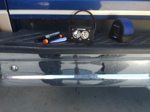 1996 Ford Bronco - An aftermarket LED light bar, Sharpie markers, and a blue roll of tape sit on the bed of a blue and tan truck.