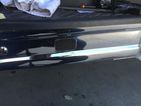 1996 Ford Bronco - A close-up of a vehicle's rear bumper shows a freshly cut opening, possibly for a trailer hitch or light.