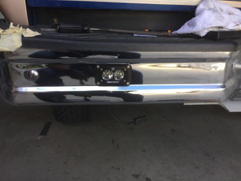 1996 Ford Bronco - Close-up of a chrome rear bumper with auxiliary lights, showing a portion of the truck bed above.