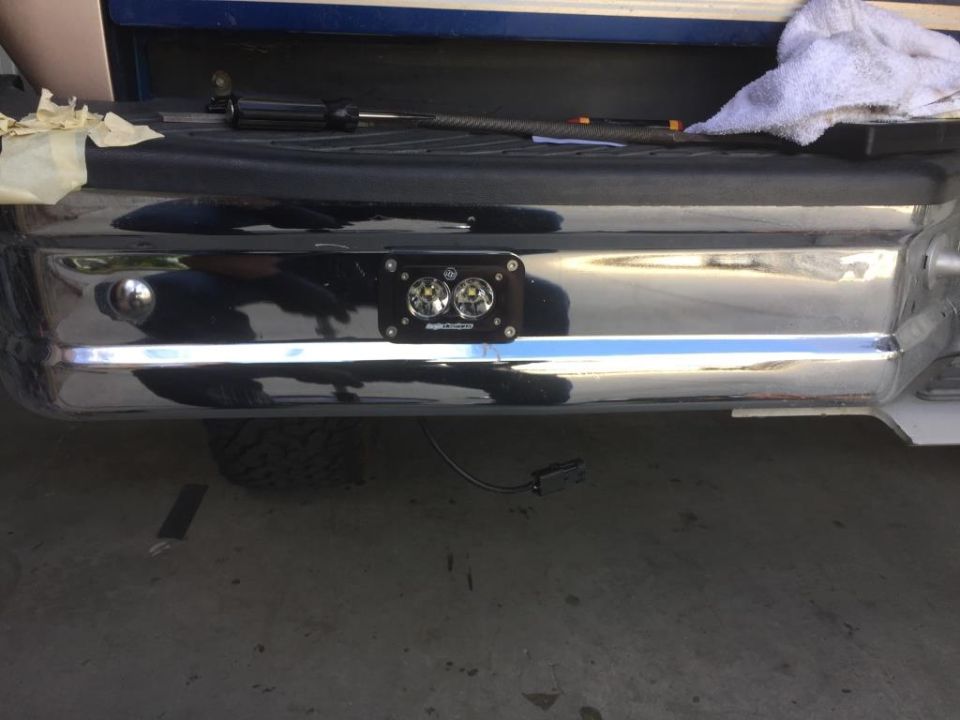 Chrome rear bumper with two auxiliary lights mounted centrally. A towel and screwdriver are on the truck bed
