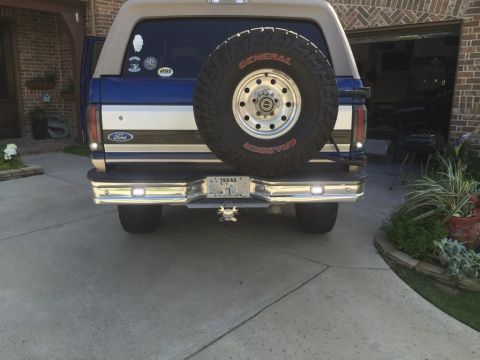 1996 Ford Bronco - Rear view of a 1996 Ford Bronco, showing the spare tire, chrome bumper, and Texas license plate.