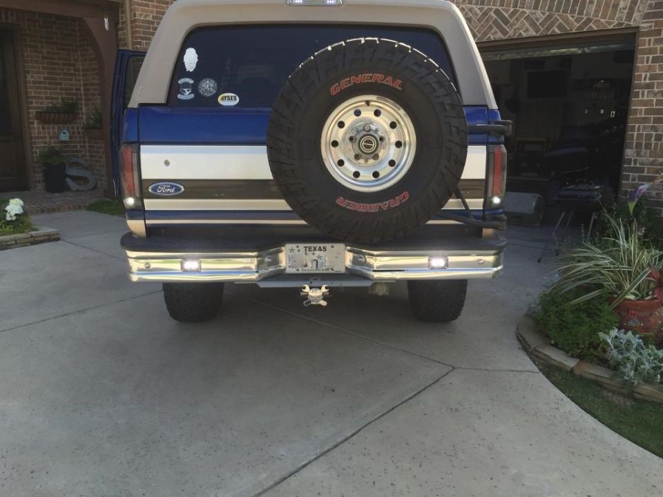 1996 Ford Bronco rear view with spare tire mounted on tailgate, Texas license plate, and chrome bumper
