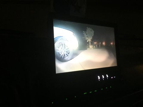 1996 Ford Bronco - A backup camera displays a tire and road at night, illuminated by headlights.