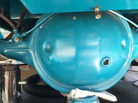 1930 Ford Coupe - Rear axle differential housing, painted teal, with visible brake lines and a square plug on the side.
