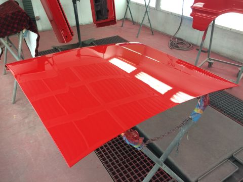 1964 Ford Fairlane - Car parts are being painted in a workshop.