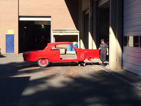 1964 Ford Fairlane - Red 1964 Ford Fairlane body shell being moved on a dolly outside a workshop.