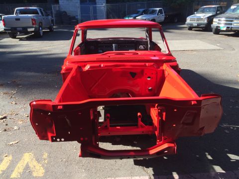 1964 Ford Fairlane - The red 1964 Ford Fairlane chassis is viewed from the front, revealing its engine bay and frame.