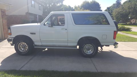 1995 Ford Bronco - Side view of a white 1995 Ford Bronco parked in a suburban driveway.