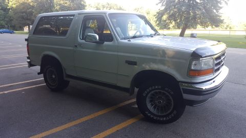 1995 Ford Bronco - A light-colored 1995 Ford Bronco is parked in a lot, viewed from the front three-quarter angle.