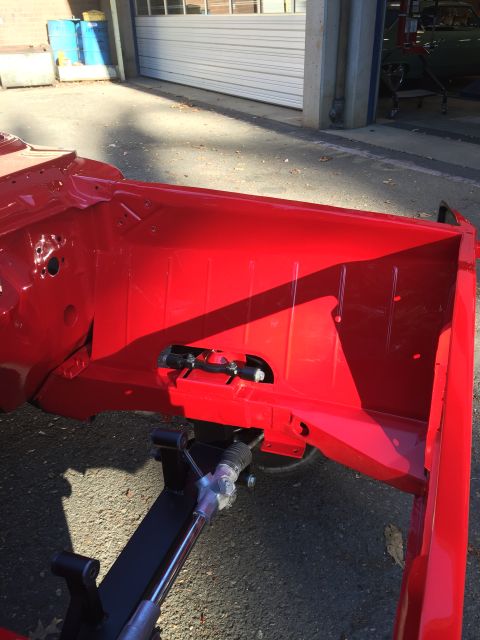 1964 Ford Fairlane - Close-up of a vehicle's red-painted chassis and steering assembly, likely during restoration.