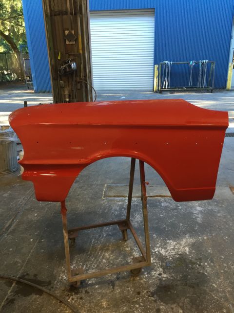1964 Ford Fairlane - A red fender, identified as from a 1964 Ford Fairlane, is mounted on a stand in what appears to be a workshop.