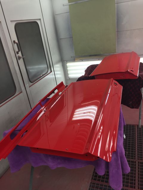 1964 Ford Fairlane - Car doors and hood freshly painted red sit in a spray booth.
