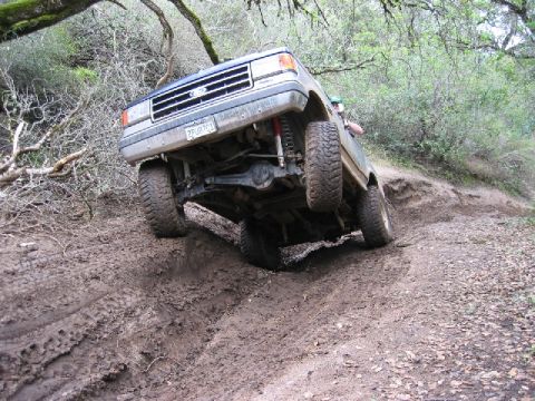 1989 Ford Bronco - This 1989 Ford Bronco navigates a challenging muddy incline on an off-road trail.