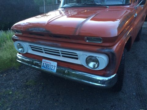 1962 Chevrolet Suburban - This orange pickup truck features a white grille and a Washington license plate. The body style suggests a 1960s model.