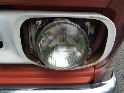 1962 Chevrolet Suburban - Headlight assembly detail on an older truck, showing wear and tear.