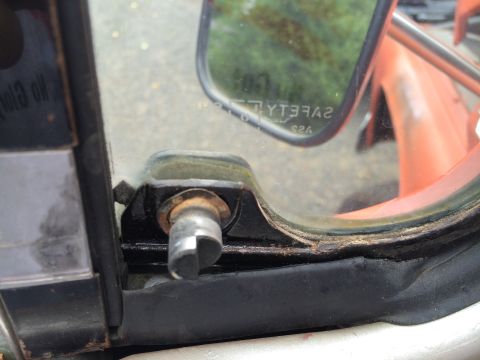 1962 Chevrolet Suburban - A detailed view of a vehicle's interior door lock mechanism and the frame of a side mirror.