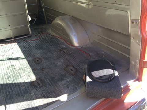 1962 Chevrolet Suburban - The cargo area of a vehicle shows a ribbed floor, a wheel well, and a speaker box.