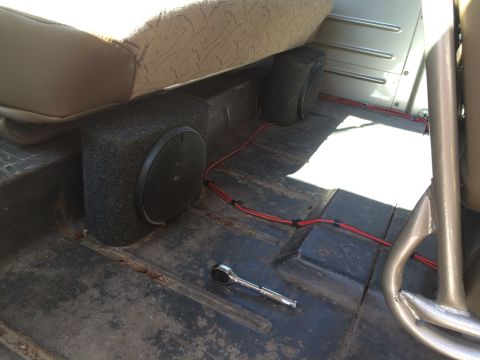 1962 Chevrolet Suburban - The interior of a vehicle shows subwoofers and wiring, with a socket wrench on the floor.