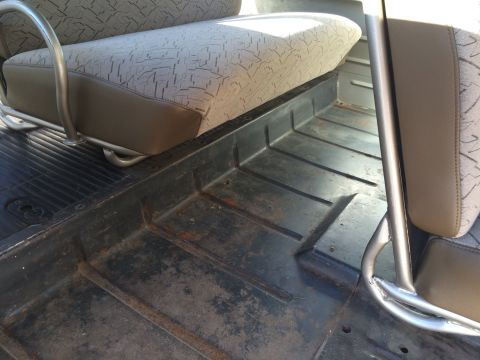 1962 Chevrolet Suburban - Vehicle interior floor and seat detail, showing wear and upholstery pattern.