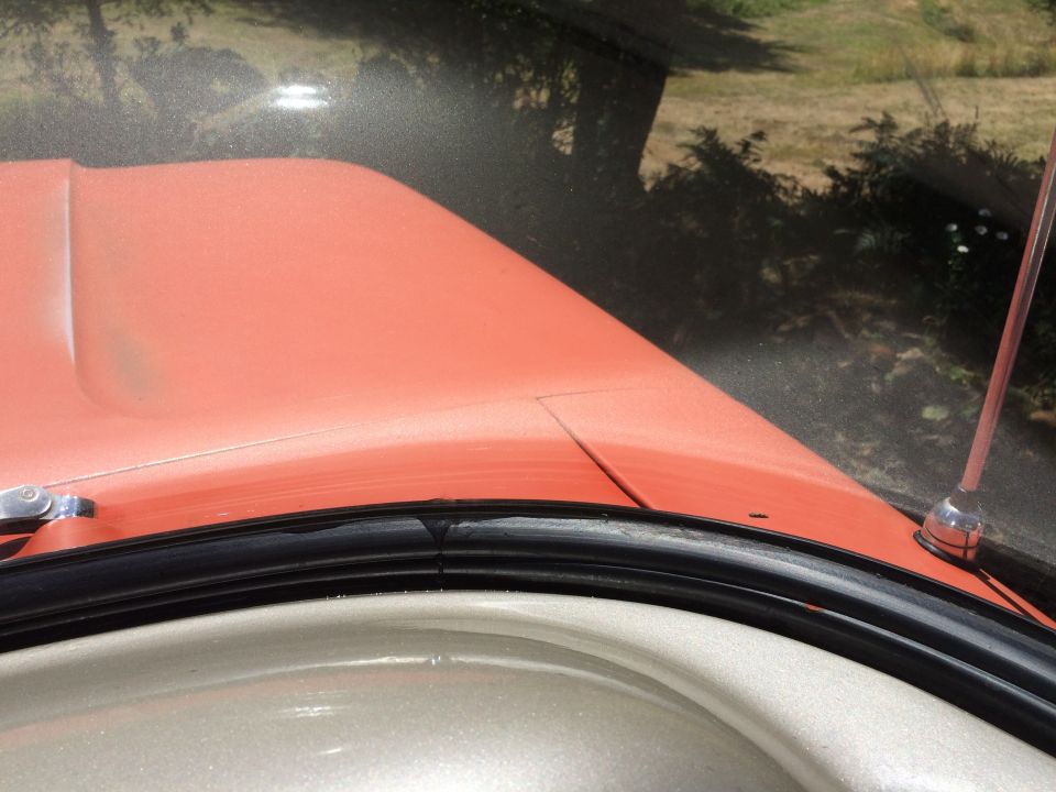 Orange hood and windshield frame with black rubber seal and chrome antenna base
