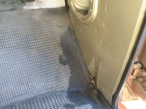 1962 Chevrolet Suburban - Close-up view of a vehicle's interior floor mat and door jamb area.