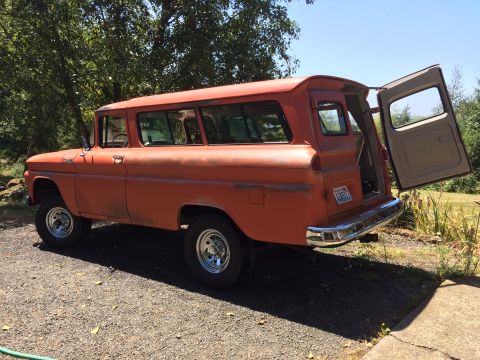 1962 Chevrolet Suburban - This vintage panel van, likely from the early 1960s, is parked outdoors with its rear doors ajar.