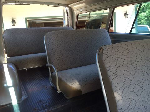 1962 Chevrolet Suburban - Interior view of a van showing two rows of bench seats with patterned upholstery and metal trim.