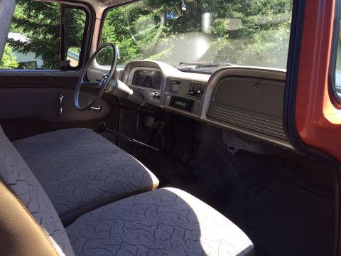 1962 Chevrolet Suburban - The interior of a vintage truck is shown, a dashboard with a radio and a bench seat.