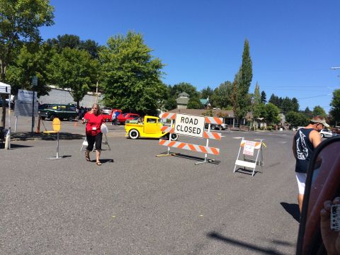 1962 Chevrolet Suburban - A yellow pickup truck is parked near a 'Road Closed' sign at an outdoor event.