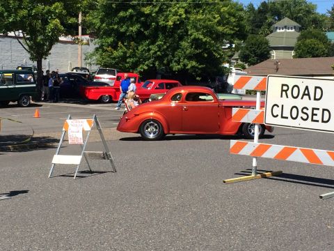 1962 Chevrolet Suburban - A custom hot rod coupe is seen at a car show, with a 'Road Closed' sign in the foreground.