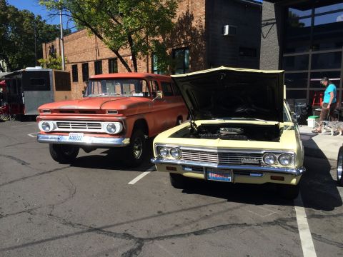 1962 Chevrolet Suburban - Two classic Chevrolet vehicles, a C10 pickup and an Impala, are parked side-by-side at an outdoor event.
