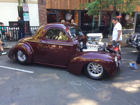 1962 Chevrolet Suburban - A custom maroon coupe with a powerful V8 engine on display at a car show.