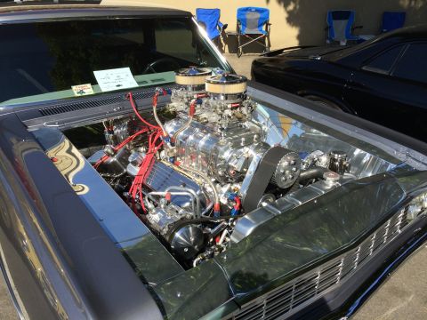 1962 Chevrolet Suburban - A highly customized engine bay is showcased, a prominent supercharger and polished components.