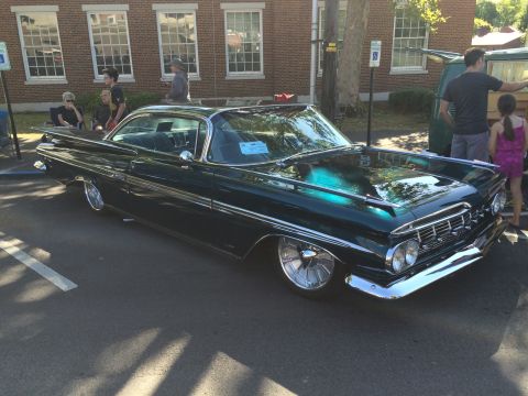 1962 Chevrolet Suburban - A 1959 Chevrolet Impala is displayed at a car show, a distinctive body style and chrome accents.