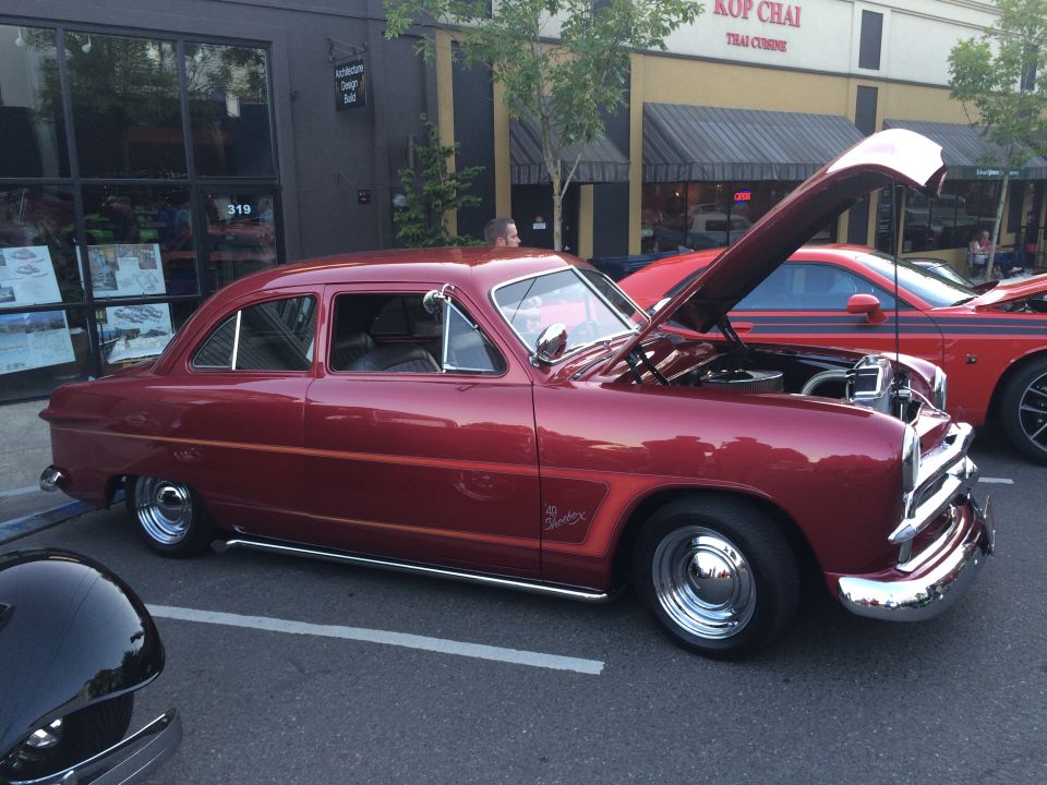 Red sedan with hood open, chrome trim, custom wheels