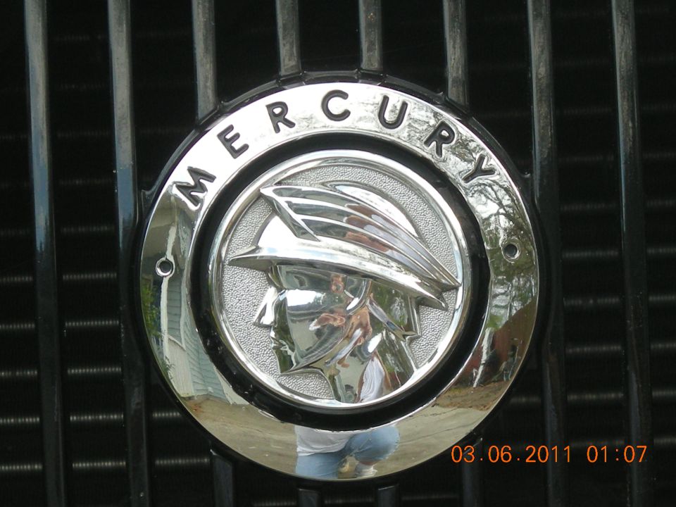 Chrome Mercury emblem with winged head on black grille, timestamp 03.06.2011