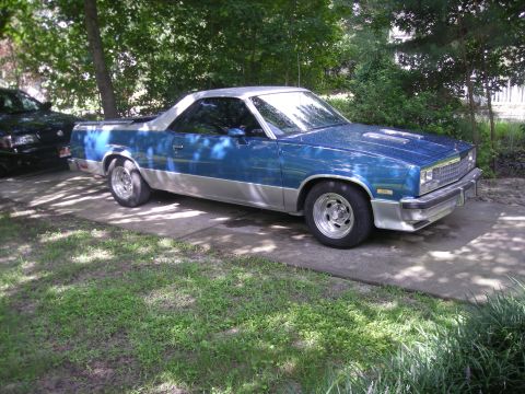 2003 Mercury Marauder - Pickup truck with a two-tone paint job sits on a concrete driveway surrounded by trees.