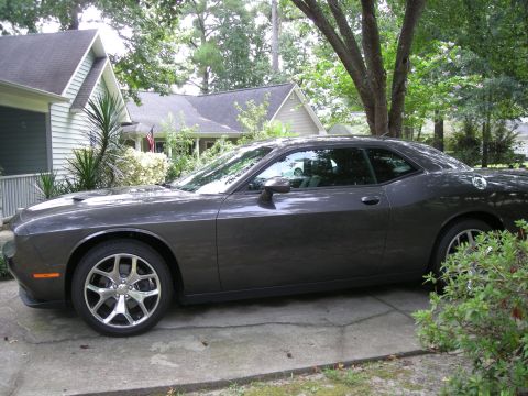 2003 Mercury Marauder - A dark gray Dodge Challenger is parked on a concrete driveway in front of a house.