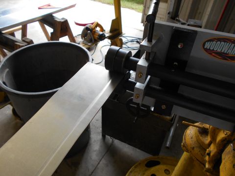 1992 Ford Bronco - A metal sheet is processed by a roller machine in a workshop setting.