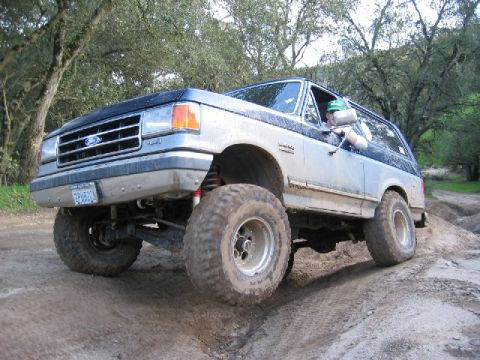 1989 Ford Bronco - This lifted Ford Bronco navigates a challenging off-road course with large tires and modified suspension.